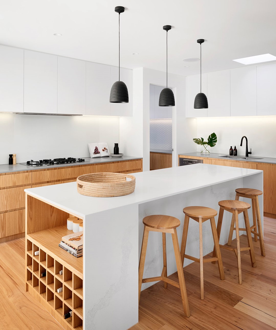 View of the same kitchen looking to the right showing the rest of the island and a sink