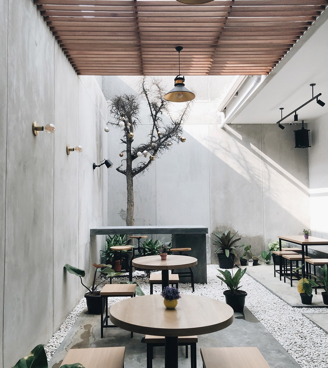 Stone room decorated with wooden tables and potted plants